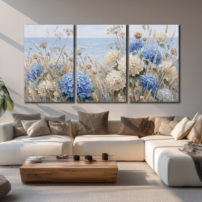 Blue hydrangeas and delicate ivory wildflowers beneath a pale blue sky 3 piece canvas wall art displayed in a living room