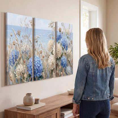 Blue hydrangeas and delicate ivory wildflowers beneath a pale blue sky 3 piece canvas wall art three panel arrangement on a wall
