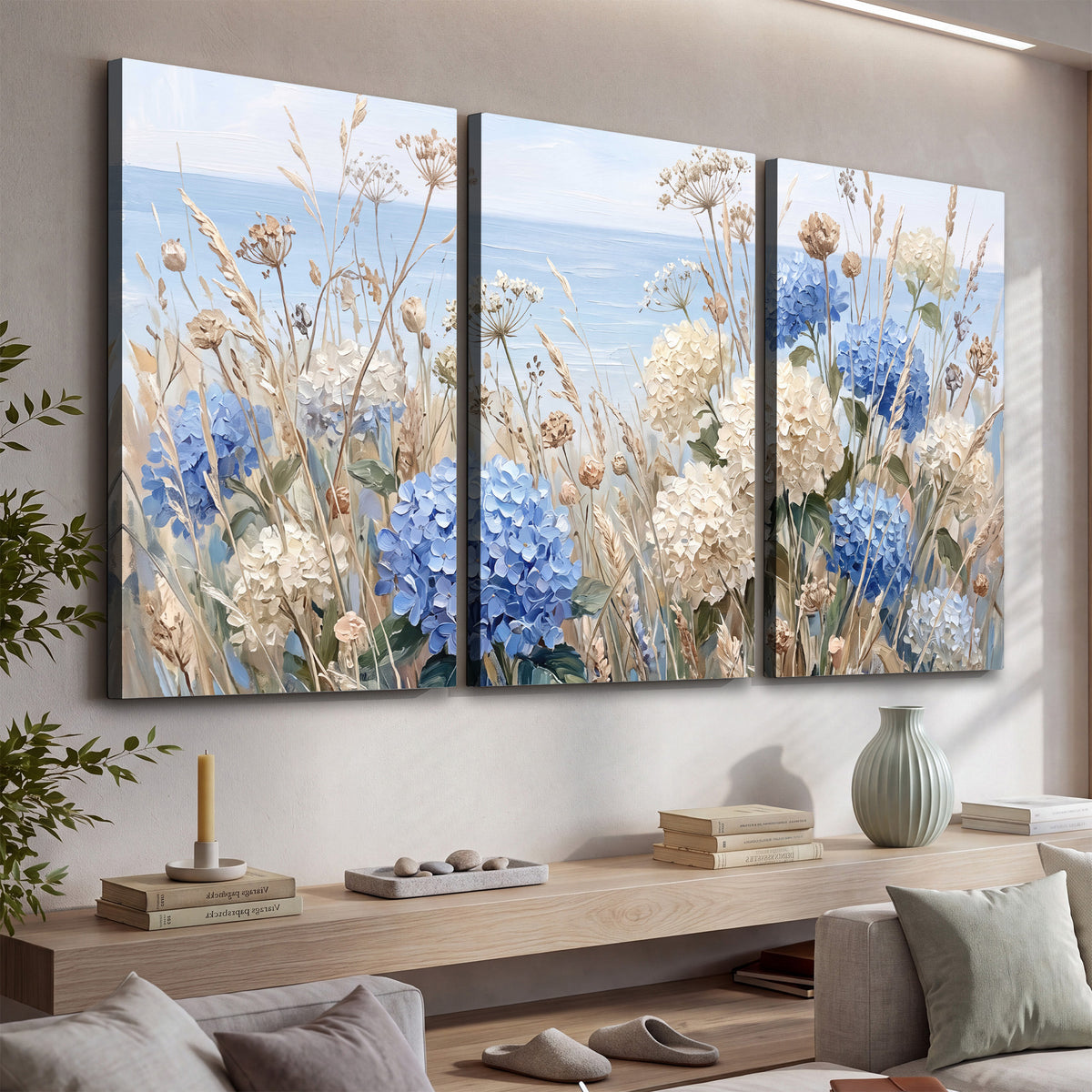 Blue hydrangeas and delicate ivory wildflowers beneath a pale blue sky 3 piece canvas wall art displayed in a console