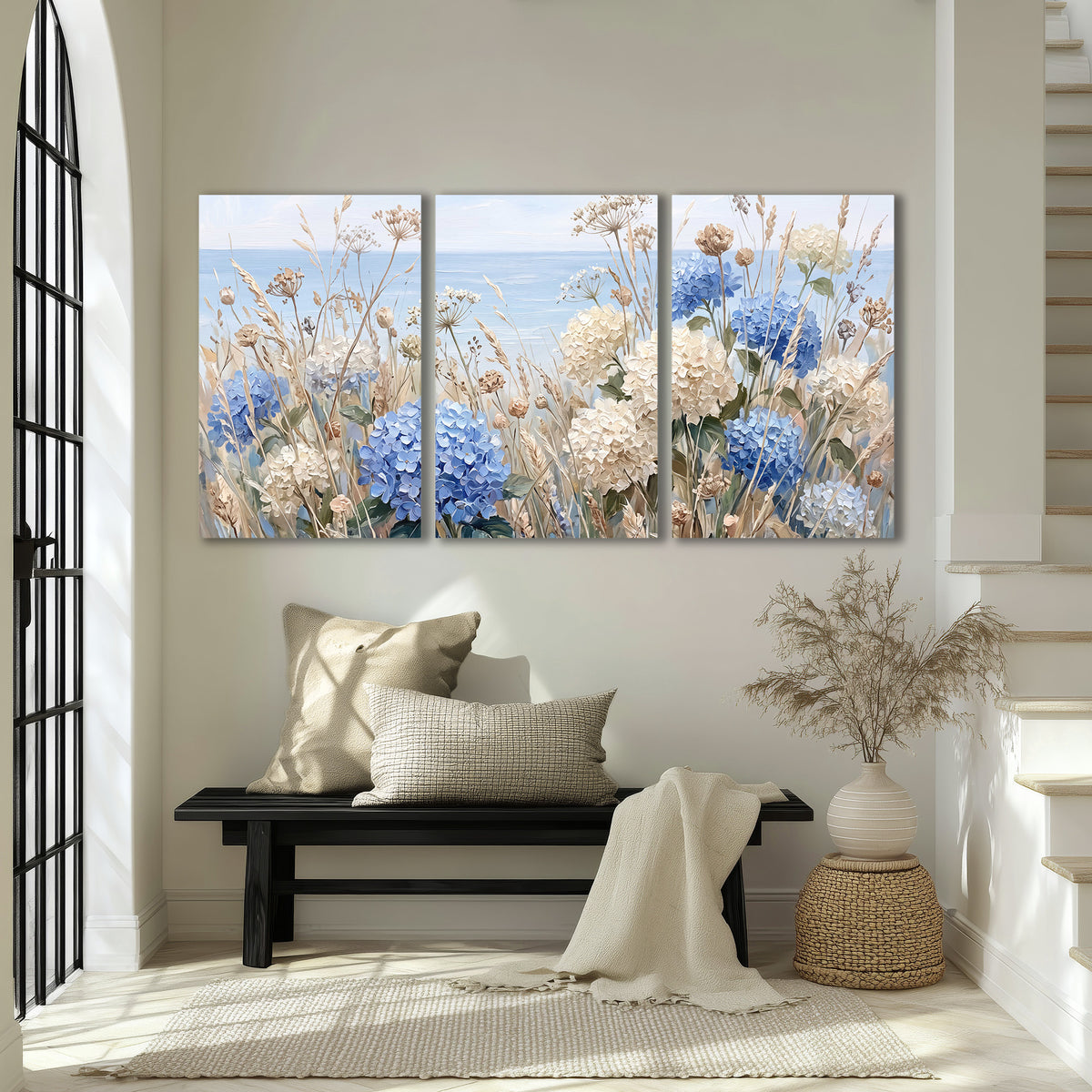 Blue hydrangeas and delicate ivory wildflowers beneath a pale blue sky 3 piece canvas wall art displayed in a entryway