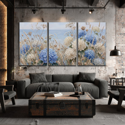 Blue hydrangeas and delicate ivory wildflowers beneath a pale blue sky 3 piece canvas wall art displayed in a industrial room