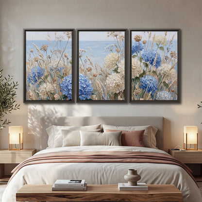 Blue hydrangeas and delicate ivory wildflowers beneath a pale blue sky 3 piece framed canvas wall art displayed in a bedroom