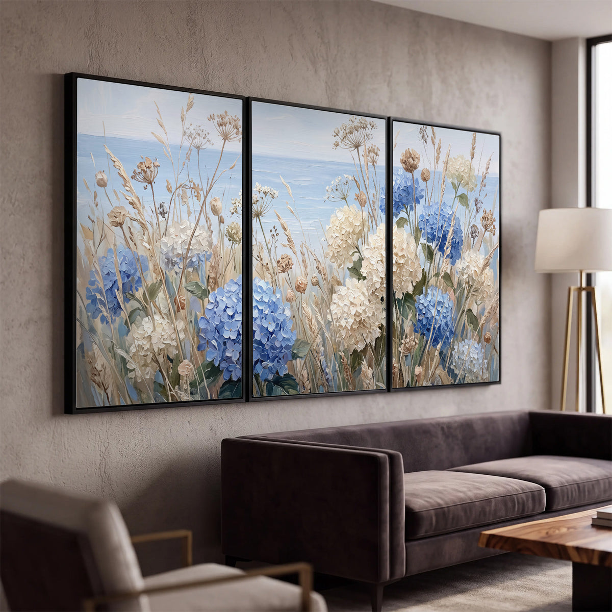Blue hydrangeas and delicate ivory wildflowers beneath a pale blue sky 3 piece framed canvas wall art displayed in a modern living room