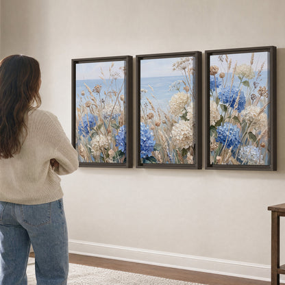 Blue hydrangeas and delicate ivory wildflowers beneath a pale blue sky 3 piece framed canvas wall art three panel arrangement on a wall