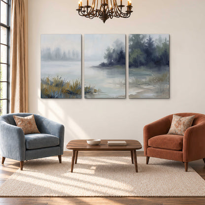 A calm pale lake bordered by dark evergreen trees and distant mist 3 piece canvas wall art styled in an interior