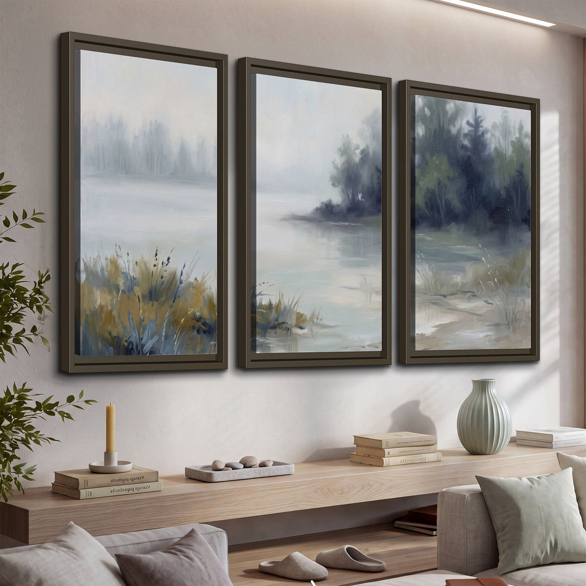 A calm pale lake bordered by dark evergreen trees and distant mist 3 piece framed canvas wall art displayed in a console