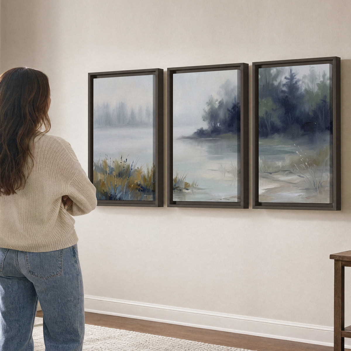 A calm pale lake bordered by dark evergreen trees and distant mist 3 piece framed canvas wall art three panel arrangement on a wall