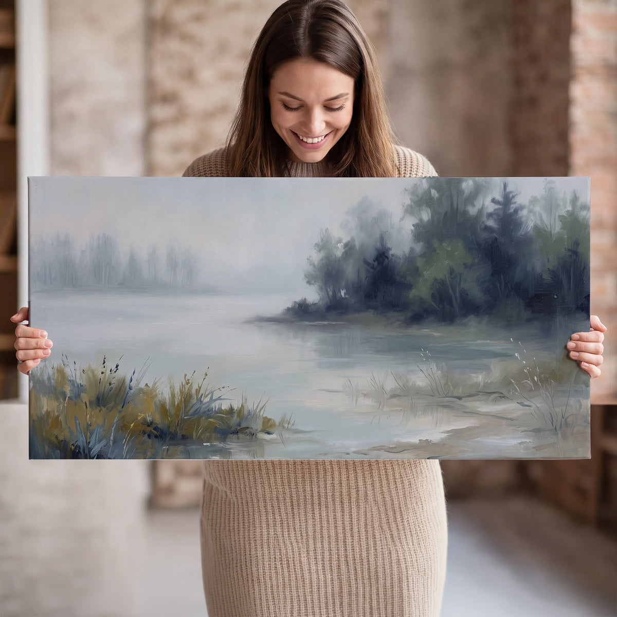A calm pale lake bordered by dark evergreen trees and distant mist single canvas wall art held in hands
