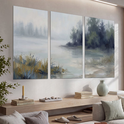 A calm pale lake bordered by dark evergreen trees and distant mist set of 3 poster prints displayed in a console