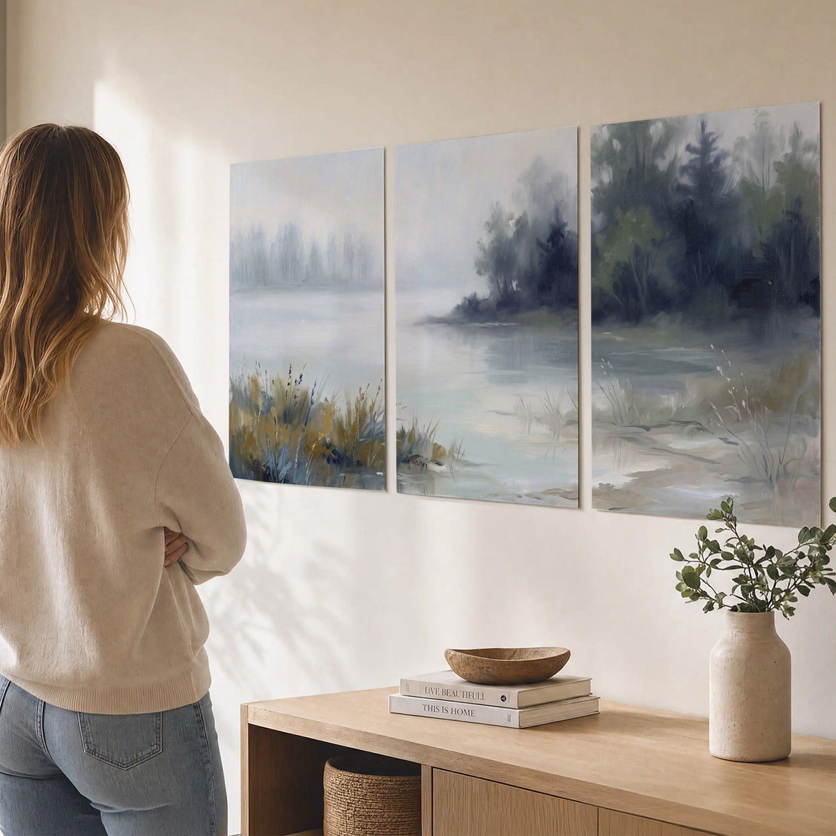 A calm pale lake bordered by dark evergreen trees and distant mist set of 3 poster prints three panel arrangement on a wall
