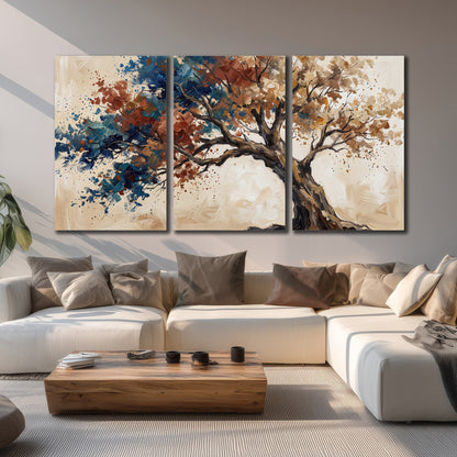 A broad tree with rust, blue and ochre foliage against warm cream 3 piece canvas wall art displayed in a living room