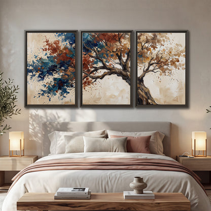 A broad tree with rust, blue and ochre foliage against warm cream 3 piece framed canvas wall art displayed in a bedroom