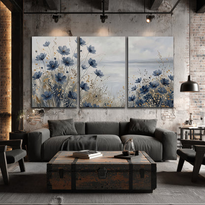 Soft blue flowers and ivory grasses beside a pale coastal horizon 3 piece canvas wall art displayed in a industrial room