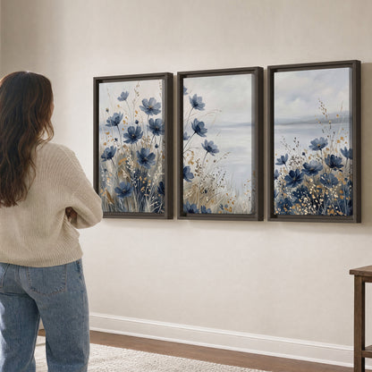 Soft blue flowers and ivory grasses beside a pale coastal horizon 3 piece framed canvas wall art three panel arrangement on a wall