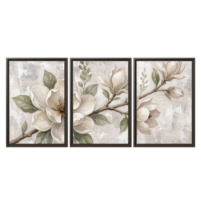 Large ivory magnolia blossoms and soft green leaves on pale gray 3 piece framed canvas wall art viewed straight on