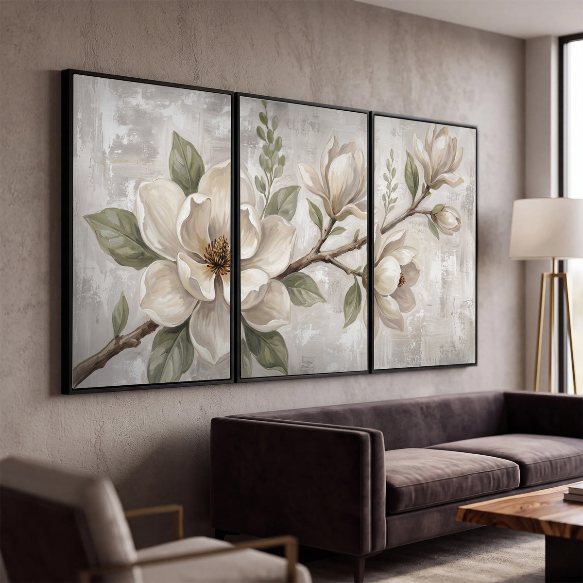 Large ivory magnolia blossoms and soft green leaves on pale gray 3 piece framed canvas wall art displayed in a modern living room