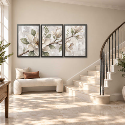 Large ivory magnolia blossoms and soft green leaves on pale gray 3 piece framed canvas wall art styled in an interior