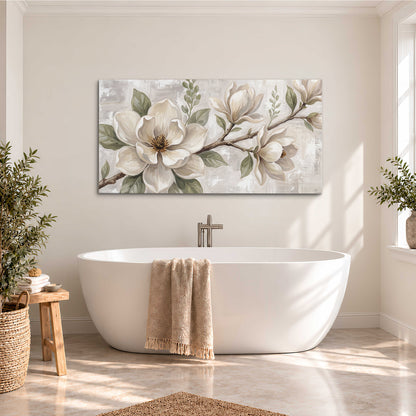 Large ivory magnolia blossoms and soft green leaves on pale gray single canvas wall art styled in an interior