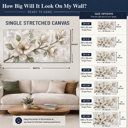 Large ivory magnolia blossoms and soft green leaves on pale gray single canvas wall art size guide above a sofa; room view is illustrative