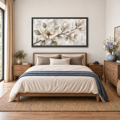 Large ivory magnolia blossoms and soft green leaves on pale gray single framed canvas wall art styled in an interior