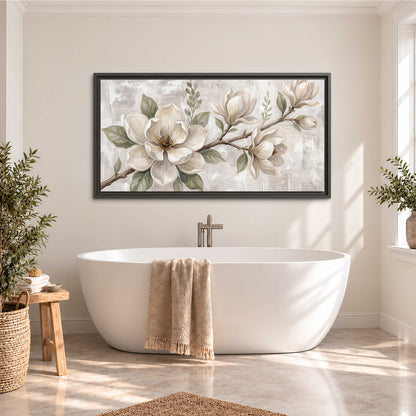 Large ivory magnolia blossoms and soft green leaves on pale gray single framed canvas wall art styled in an interior
