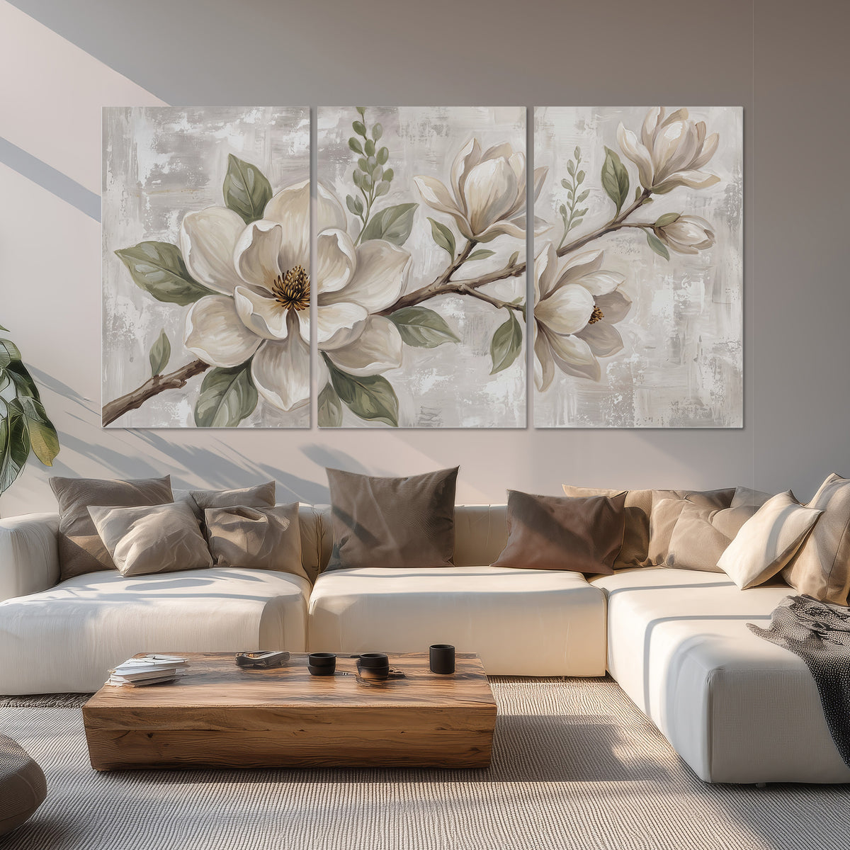 Large ivory magnolia blossoms and soft green leaves on pale gray set of 3 poster prints displayed in a living room