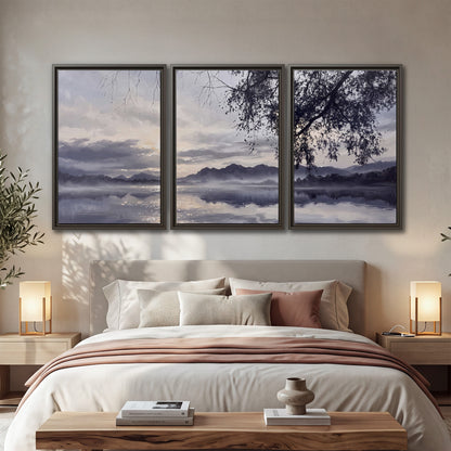 Quiet gray-blue water and dark overhanging branches beneath evening clouds 3 piece framed canvas wall art displayed in a bedroom