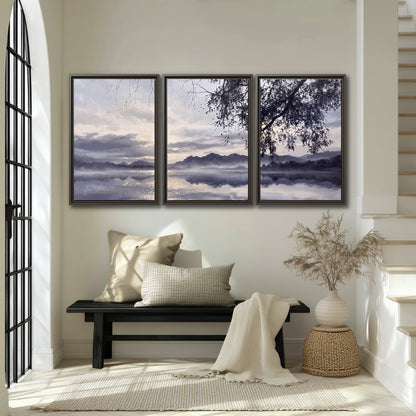 Quiet gray-blue water and dark overhanging branches beneath evening clouds 3 piece framed canvas wall art displayed in a entryway