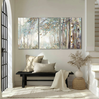 Slender woodland trunks and delicate branches in soft green and cream 3 piece canvas wall art displayed in a entryway