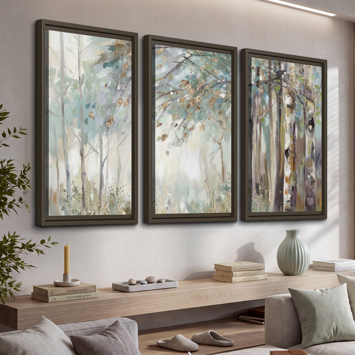 Slender woodland trunks and delicate branches in soft green and cream 3 piece framed canvas wall art displayed in a console