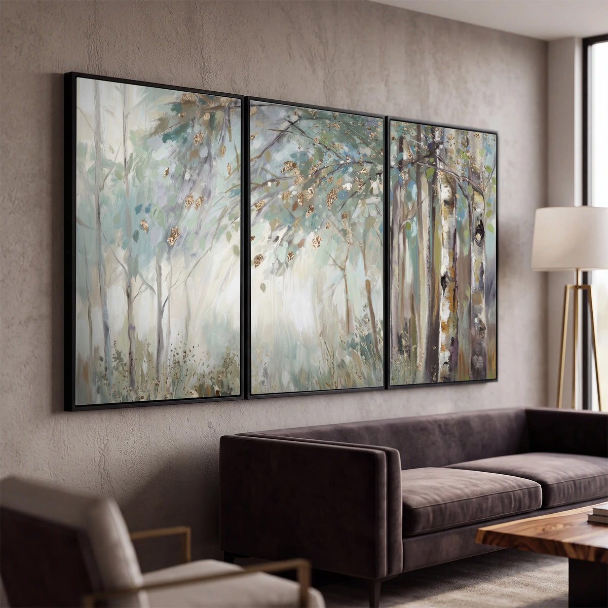 Slender woodland trunks and delicate branches in soft green and cream 3 piece framed canvas wall art displayed in a modern living room
