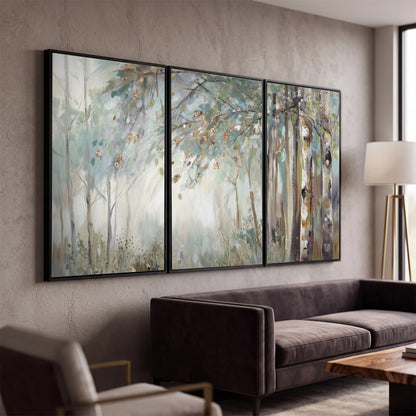 Slender woodland trunks and delicate branches in soft green and cream 3 piece framed canvas wall art displayed in a modern living room