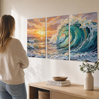 A curling turquoise ocean wave beneath a warm orange sunset set of 3 poster prints three panel arrangement on a wall