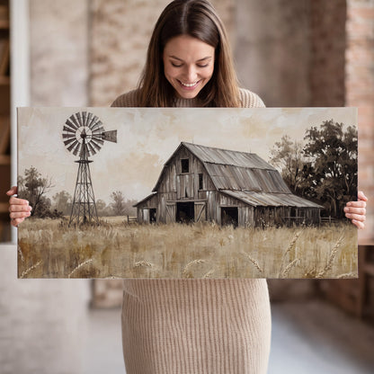A weathered wooden barn and windmill in a golden country field single canvas wall art held in hands