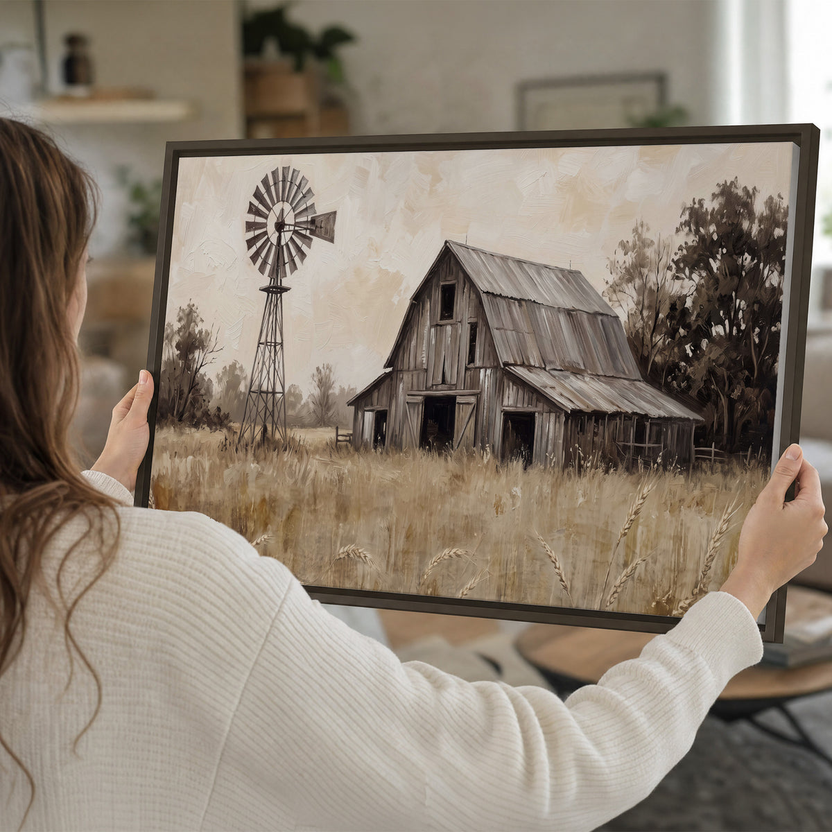 A weathered wooden barn and windmill in a golden country field single framed canvas wall art held in hands