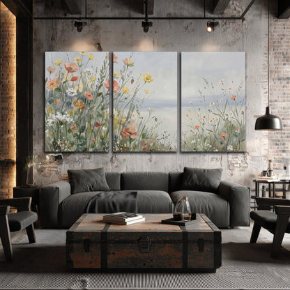 Small colorful wildflowers and light grasses beside a pale lake 3 piece canvas wall art displayed in a industrial room