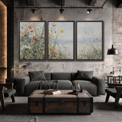 Small colorful wildflowers and light grasses beside a pale lake 3 piece framed canvas wall art displayed in a industrial room