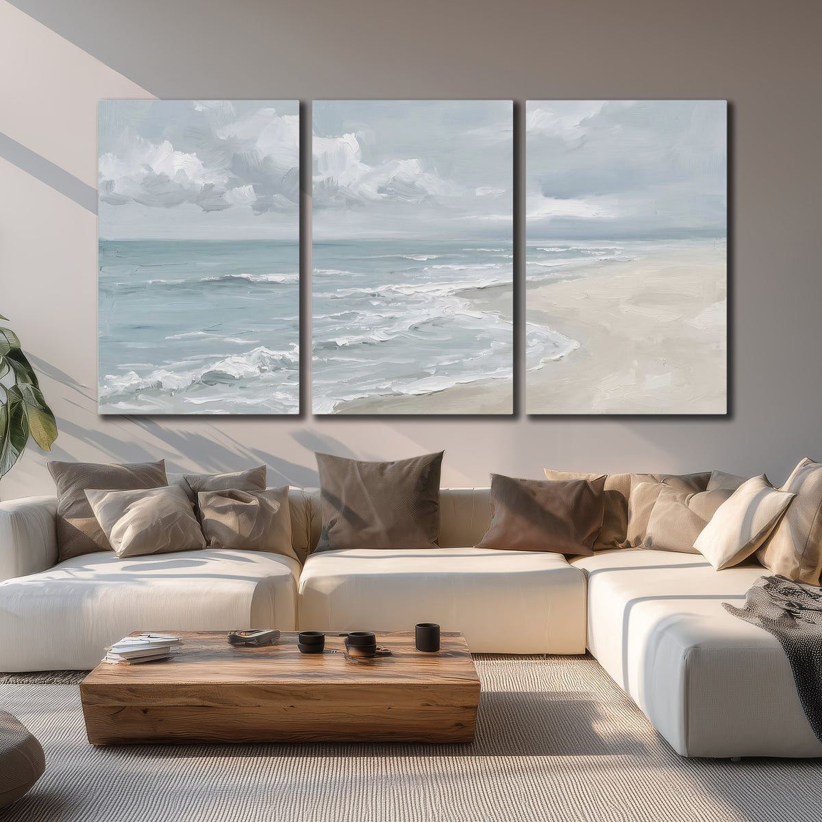 Gentle pale blue waves washing across a light sandy beach 3 piece canvas wall art displayed in a living room
