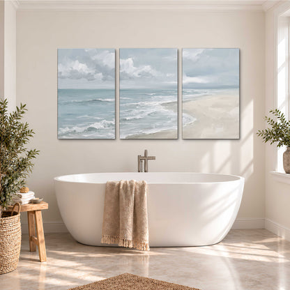 Gentle pale blue waves washing across a light sandy beach 3 piece canvas wall art styled in an interior