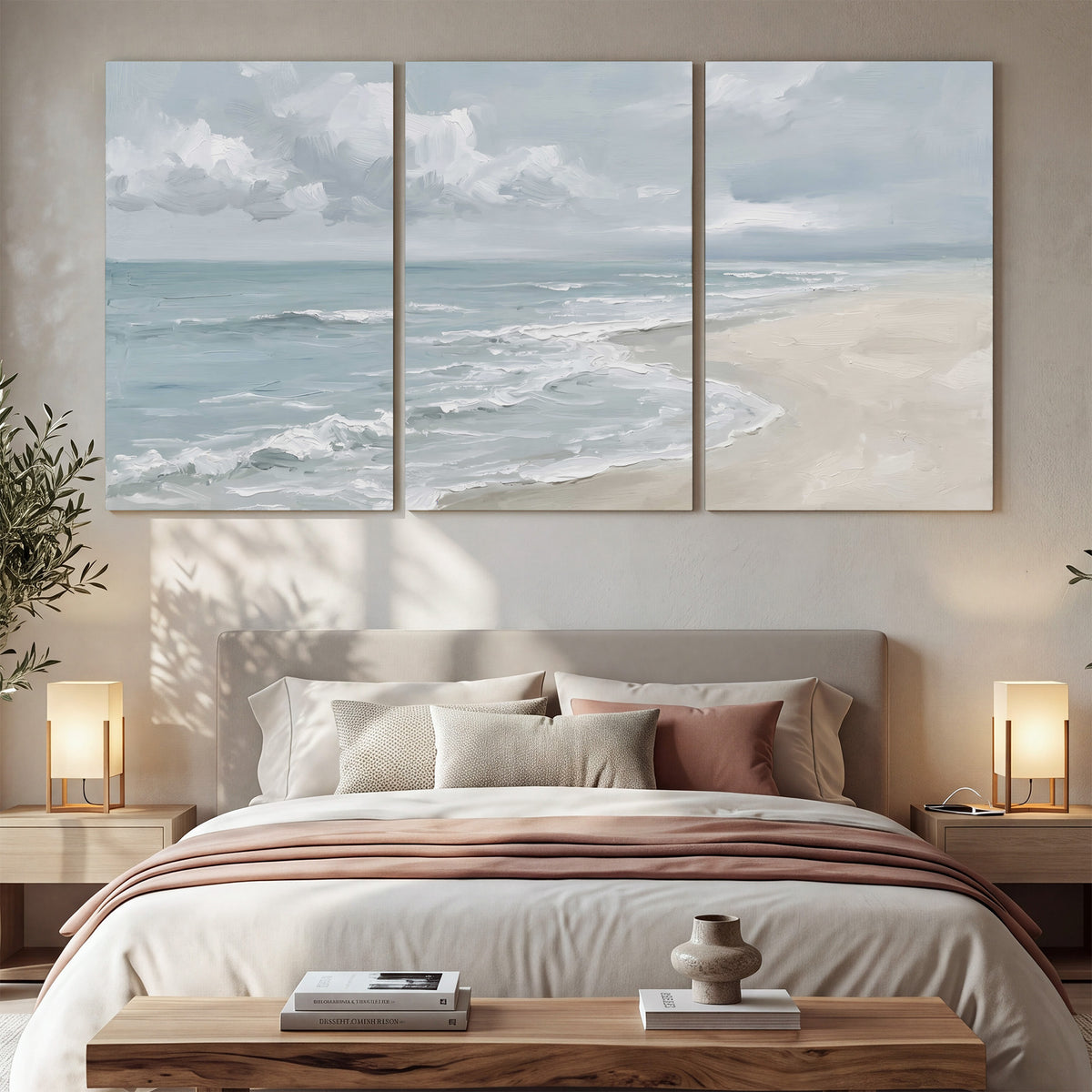 Gentle pale blue waves washing across a light sandy beach 3 piece canvas wall art displayed in a bedroom