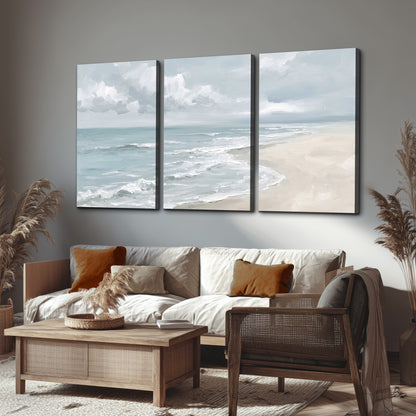 Gentle pale blue waves washing across a light sandy beach 3 piece canvas wall art displayed in a rustic living room