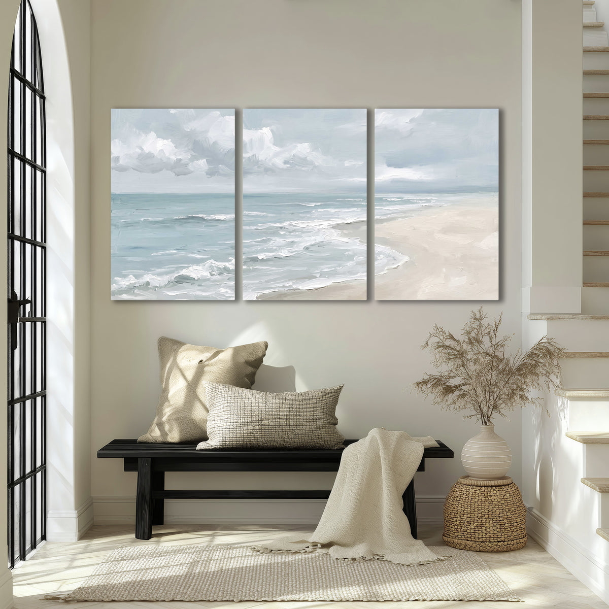 Gentle pale blue waves washing across a light sandy beach 3 piece canvas wall art displayed in a entryway