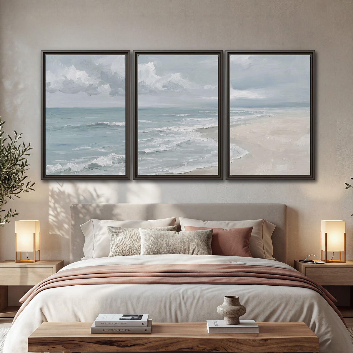Gentle pale blue waves washing across a light sandy beach 3 piece framed canvas wall art displayed in a bedroom