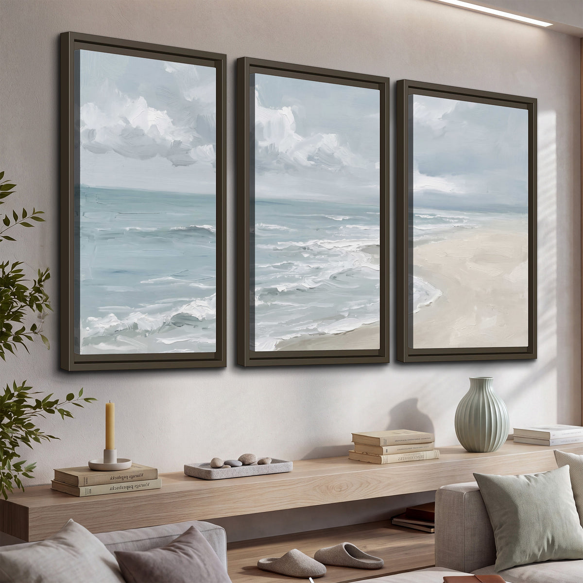 Gentle pale blue waves washing across a light sandy beach 3 piece framed canvas wall art displayed in a console