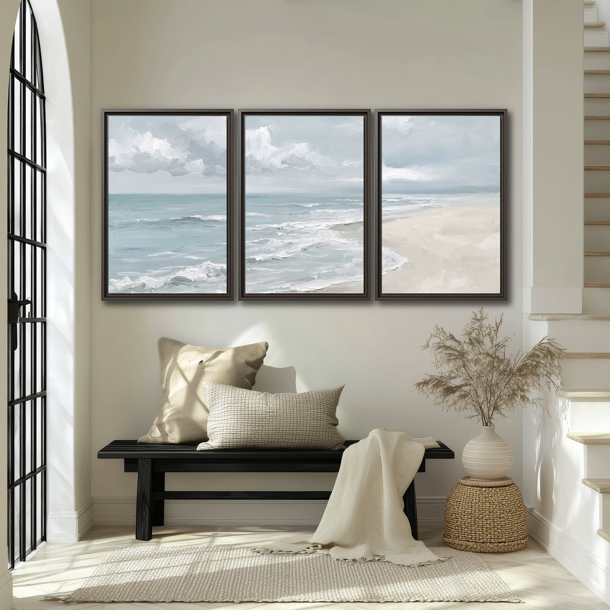 Gentle pale blue waves washing across a light sandy beach 3 piece framed canvas wall art displayed in a entryway