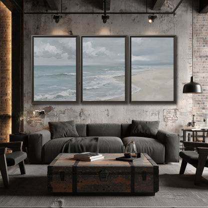 Gentle pale blue waves washing across a light sandy beach 3 piece framed canvas wall art displayed in a industrial room