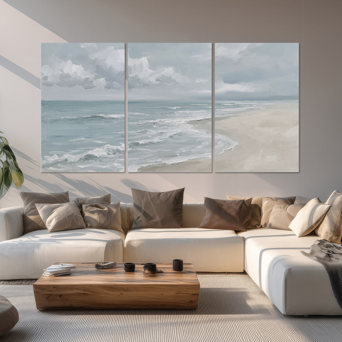 Gentle pale blue waves washing across a light sandy beach set of 3 poster prints displayed in a living room
