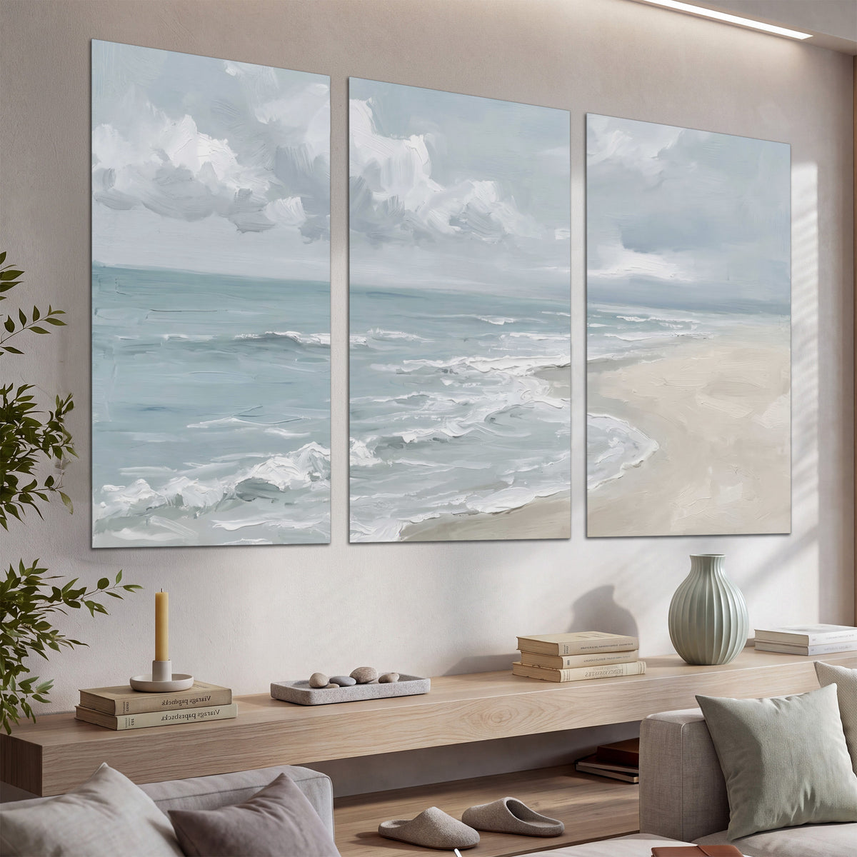 Gentle pale blue waves washing across a light sandy beach set of 3 poster prints displayed in a console