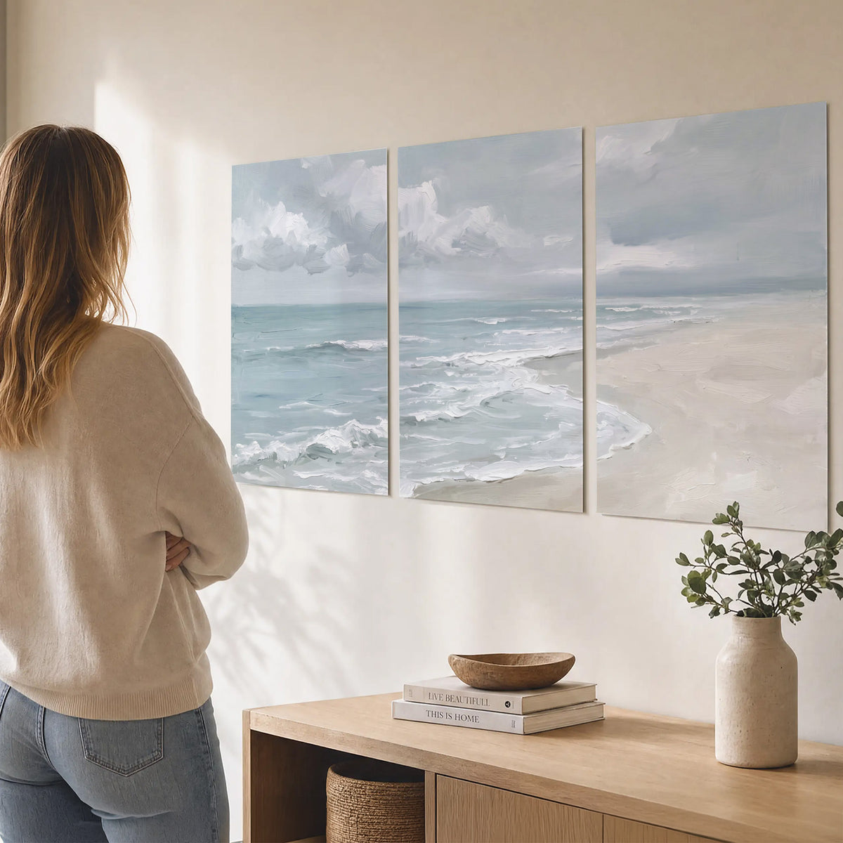 Gentle pale blue waves washing across a light sandy beach set of 3 poster prints three panel arrangement on a wall