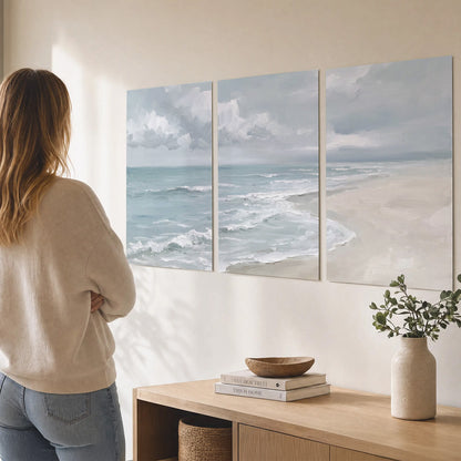 Gentle pale blue waves washing across a light sandy beach set of 3 poster prints three panel arrangement on a wall